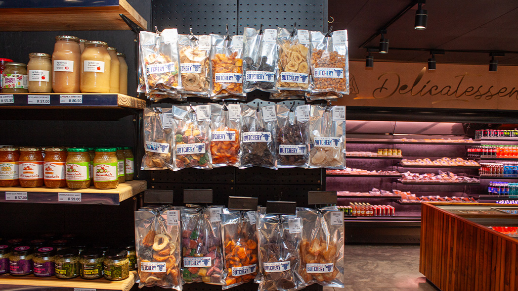 Bags of dried fruit in front of the delicatessen fridges
